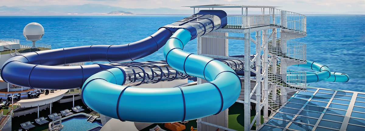 two blue waterslides are side by side with the ocean in the background