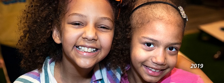 two young girls smiling in 2019