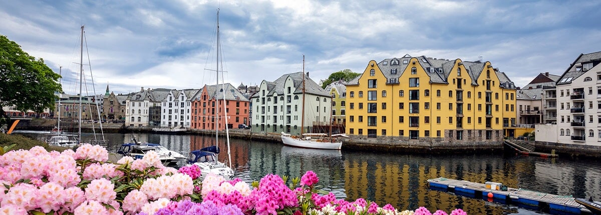 homes and boats nestled on a canal in alesund, norway