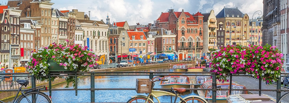 bicycles on a bridge over a canal with colorful buildings