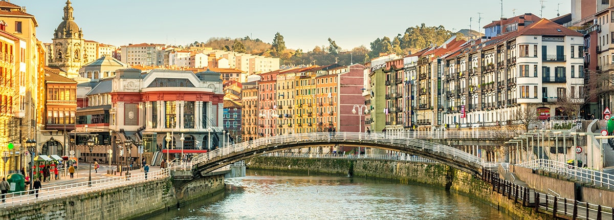the ria del bilbao running through the city surrounded by colorful buildings