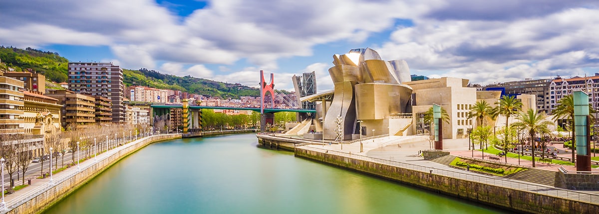 the guggenheim museums and other colorful buildings along the ria del bilbao