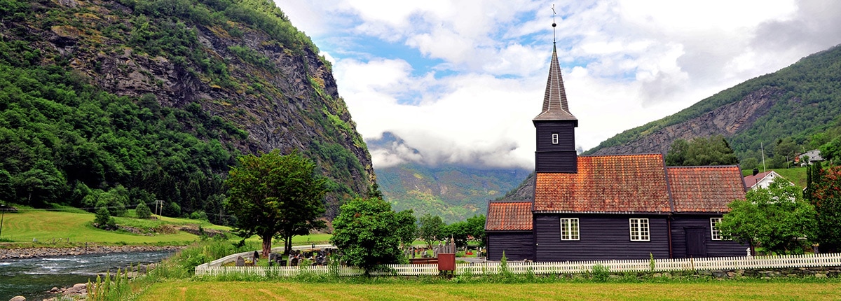old, wooden flam stave church nestled in a mountain in flaam, norway