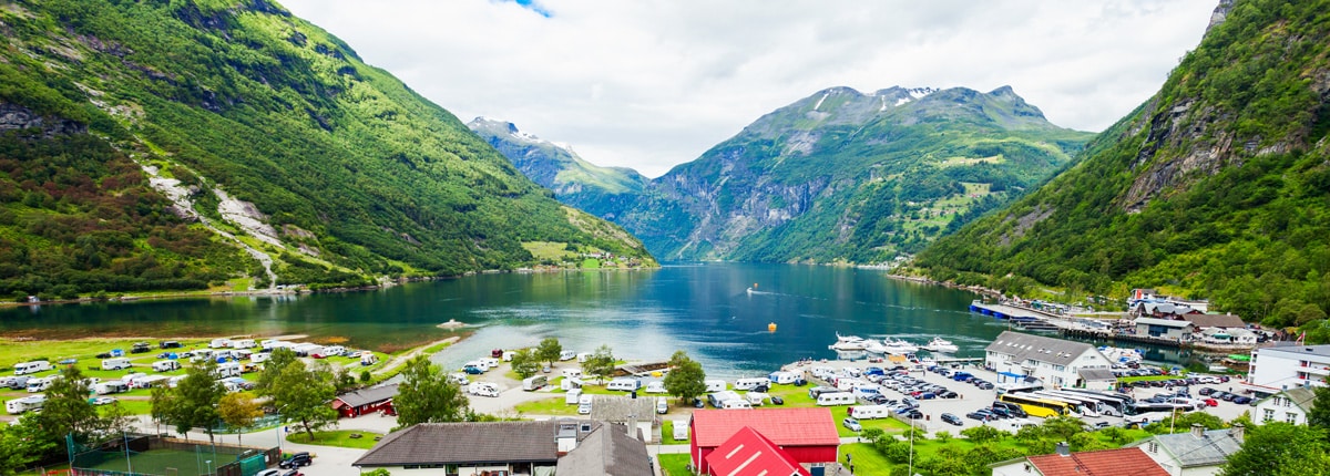 a small town surrounded by a fjord and green mountains