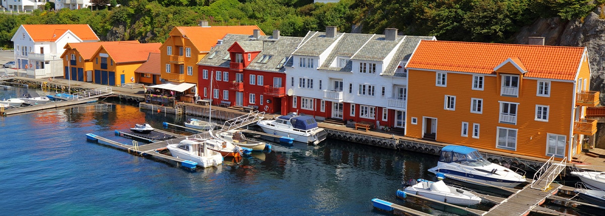 colorful houses lining a canal with boats docked in haugesund