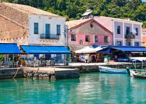 colorful boats and shops line the pier in katakolon, greece