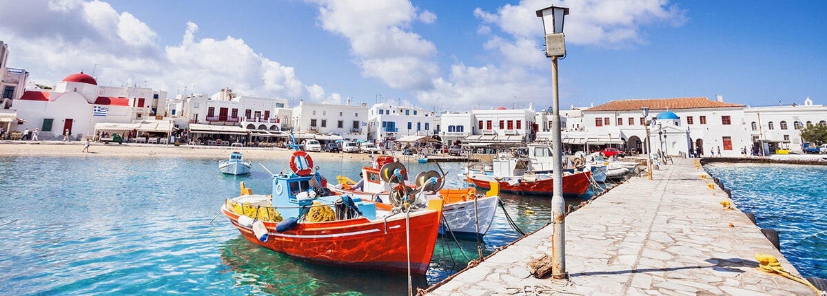 colorful wooden boats along the pier in mykonos, greece