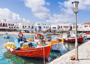 colorful wooden boats along the pier in mykonos, greece