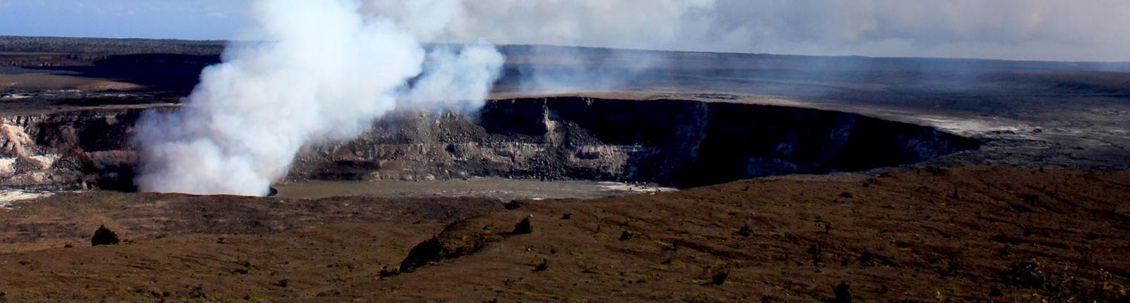 A lava tube emitting thick smoke in Hilo, Hawaii