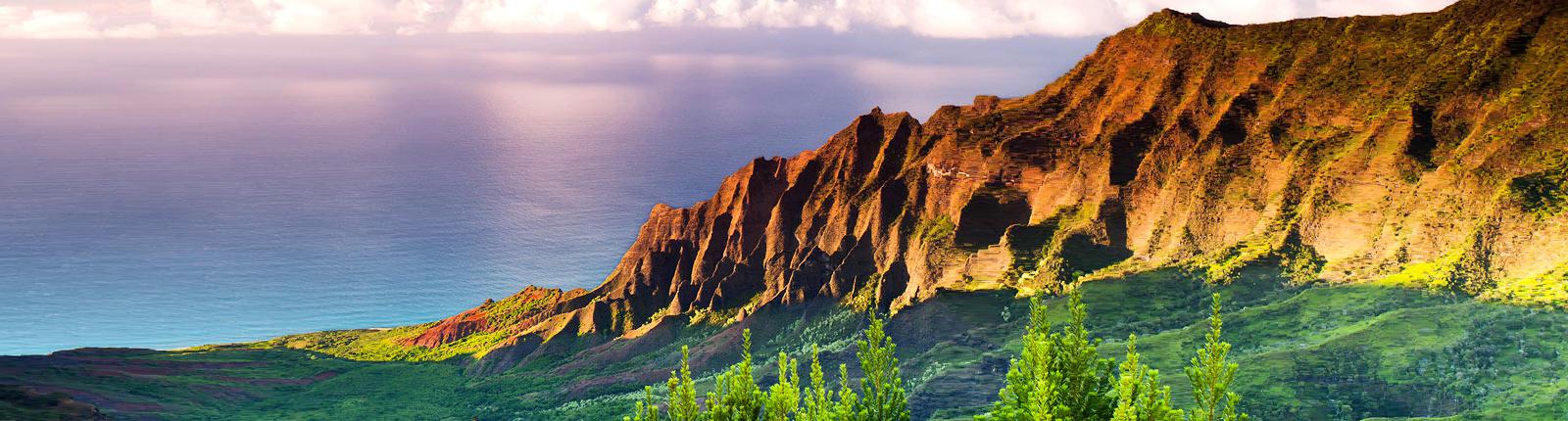 Colorful mountains overlooking blue ocean waters in Kauai, Hawaii