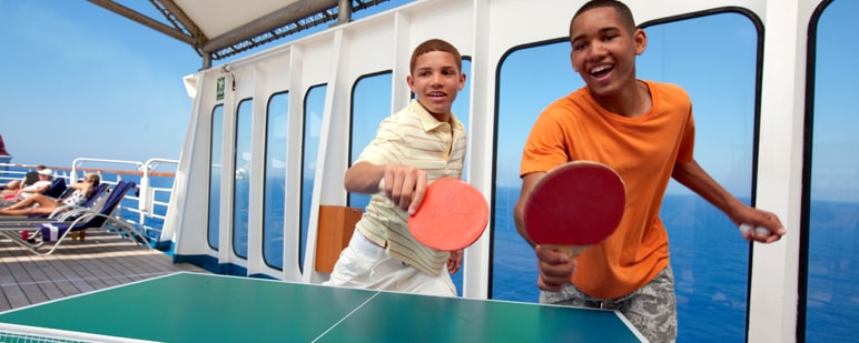 two boys playing ping pong onboard a carnival cruise