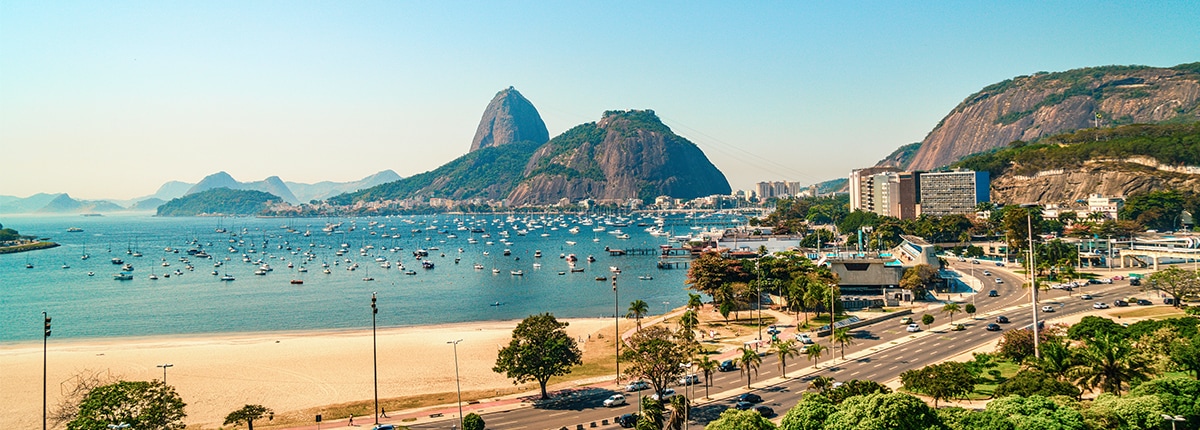 the long stretch of copacabana beach with mountains in the background in brazil