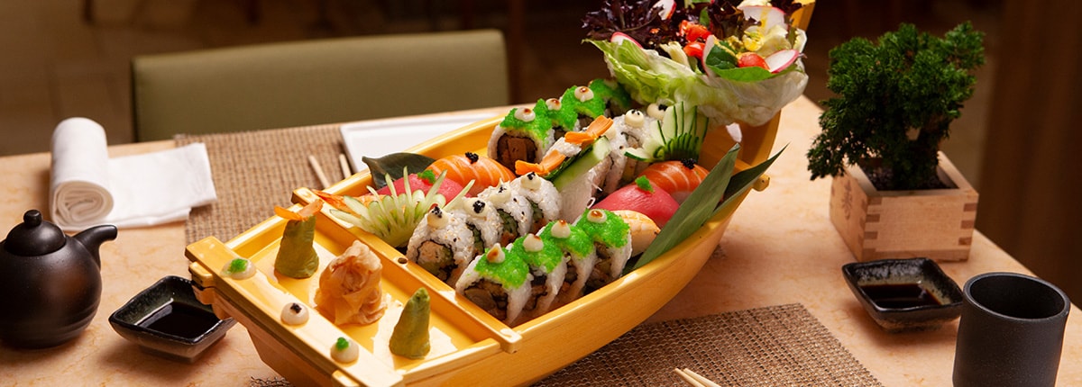 sushi is placed on a decorated boat at bonsai sushi