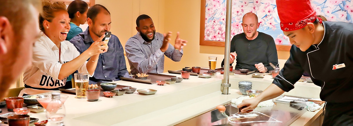 guests cheer as they watch a chef prepare a meal at bonsai teppanyaki