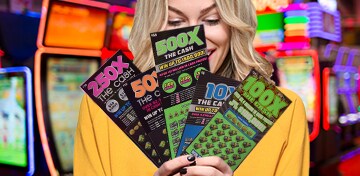 a woman fans out five scratch off cards