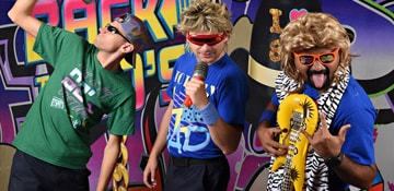 guests dressed in 80s attire and posing for a fun picture