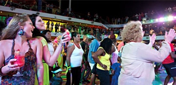 Carnival cruise vacationers dancing on the Lido deck at the Mega Deck Party