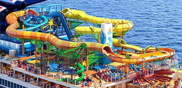 an orange blue and yellow waterslide are located on deck onboard carnival festivale