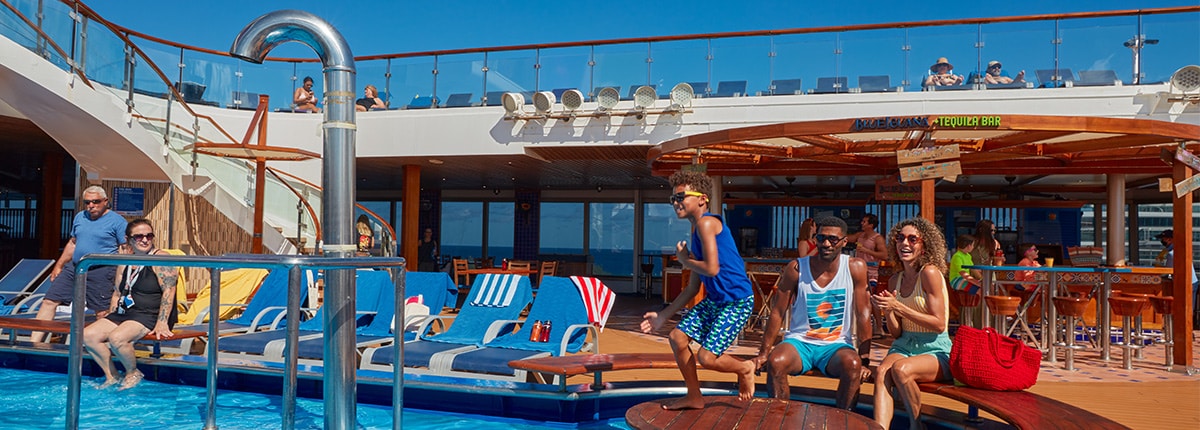 guest relaxing by the lido pool onboard a carnival cruise ship