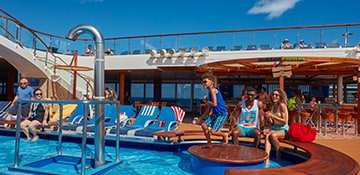 guest relaxing by the lido pool onboard a carnival cruise ship