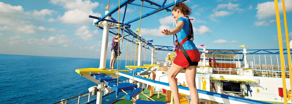 girl walking the ropes course overlooking the ocean