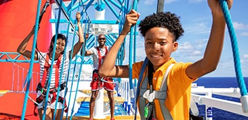 family of three walking the ropes course on a carnival cruise