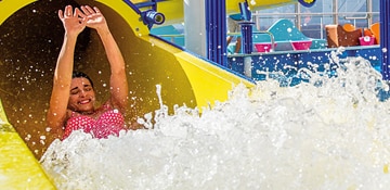 a woman splashing at teh end of the twister waterslide