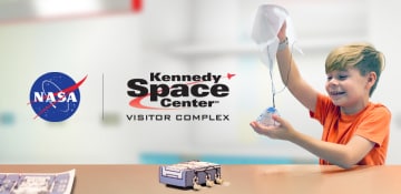 a boy plays with models of space rover and reentry capsule; nasa and kennedy space center logos