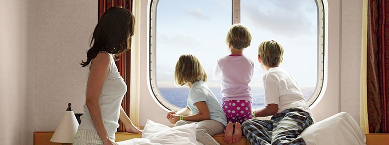 mom and children stare out their oceanview stateroom