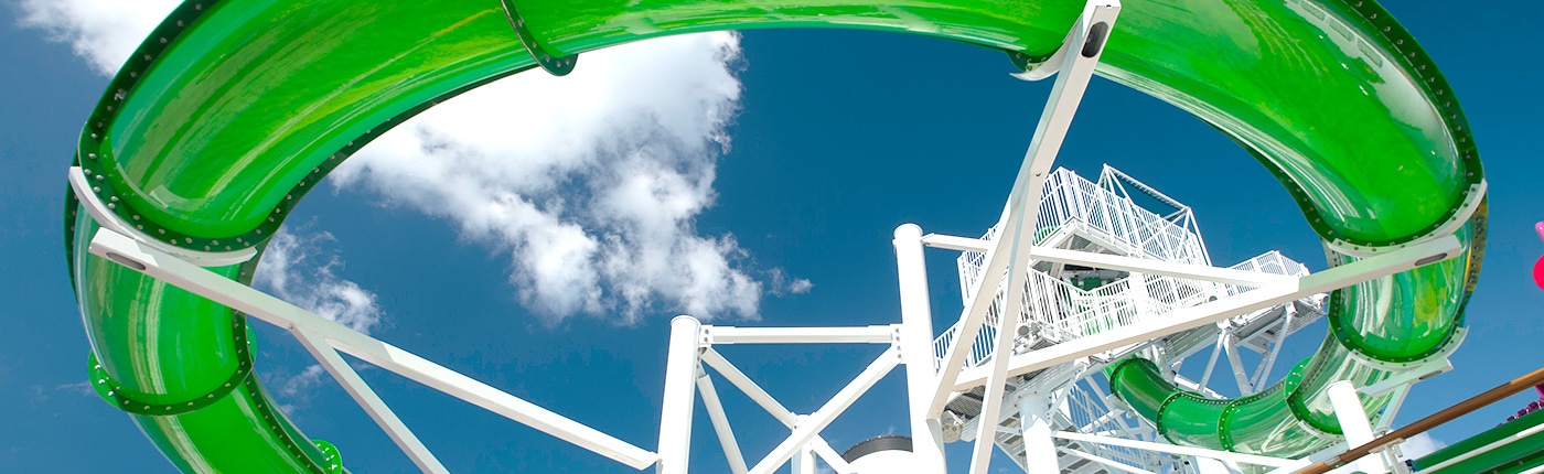 green slide on carnival spirit is held up by white steal beams