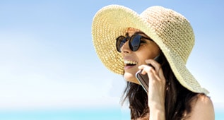 a woman with sunglass and sun hat on a cell phone