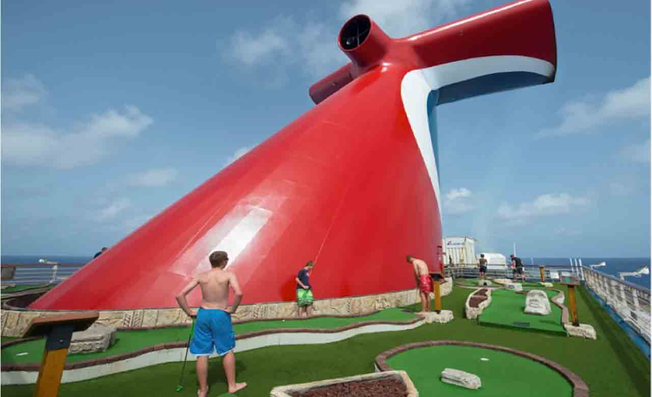 A group of boys play mini-golf next to the Carnival ship funnel