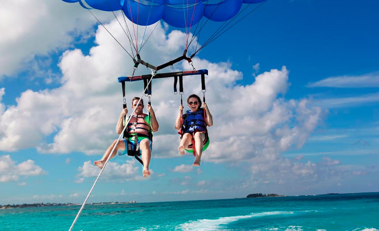 Man and woman embarking on a parasail on a carnival vacation