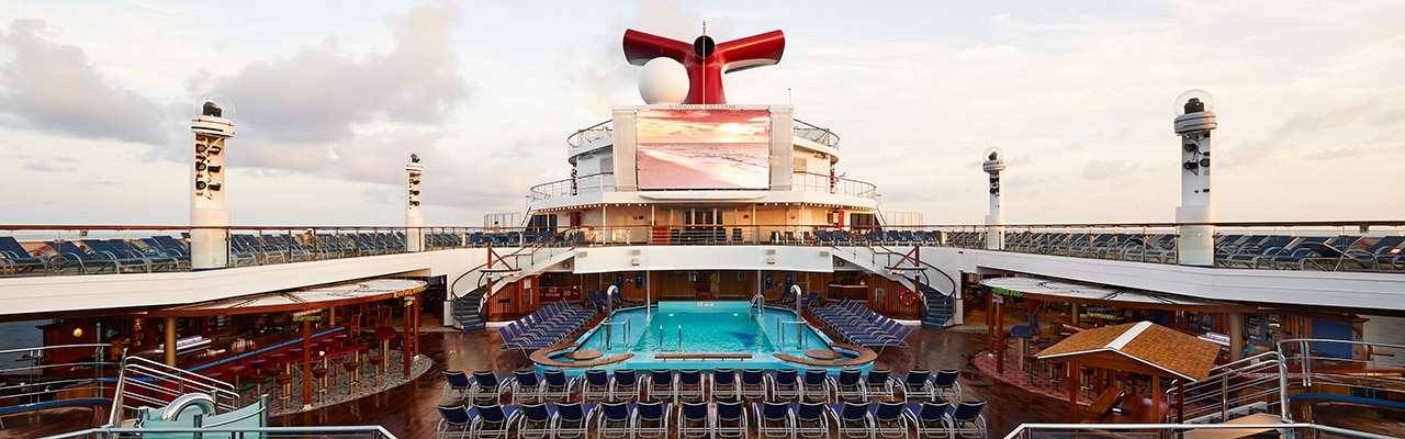 The pool, bars, large screen and Carnival funnel on the ship's deck