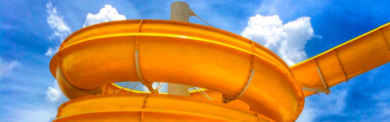 A bright orange waterslide in front of a clear sky