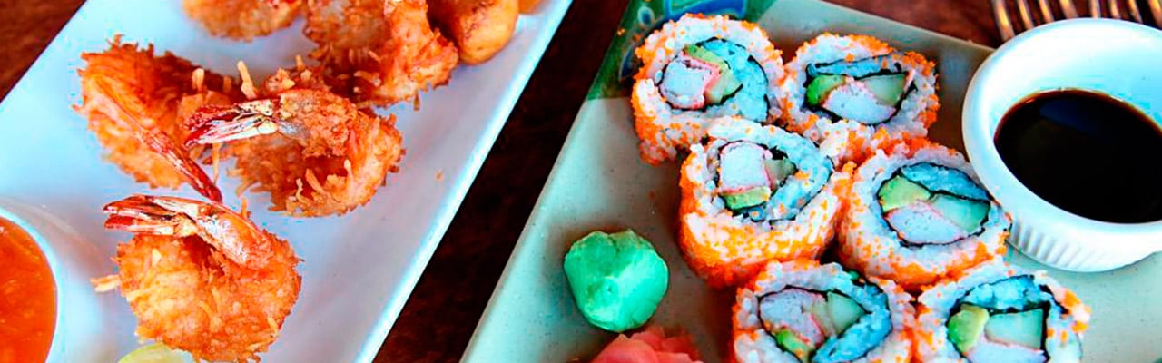 Two plates, one with coconut shrimp, the other sushi