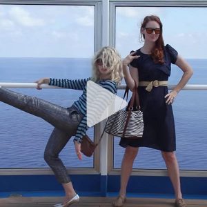 two girls with glasses stand posing on Carnival cruise ship showing off their outfits, link to Youtube video