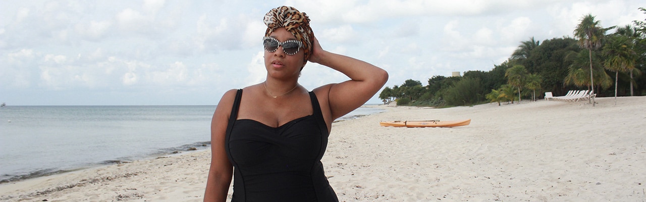 Woman touches head on empty beach