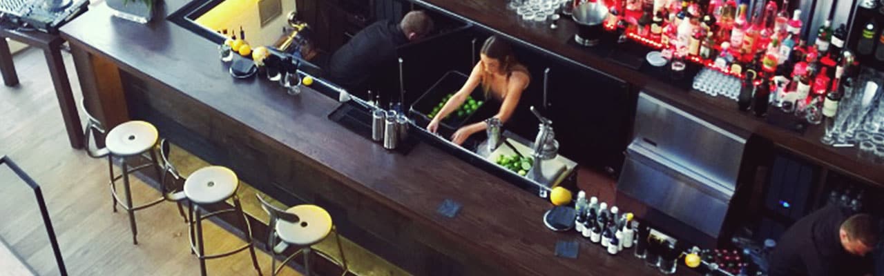 looking down at an empty bar as staff works to restock