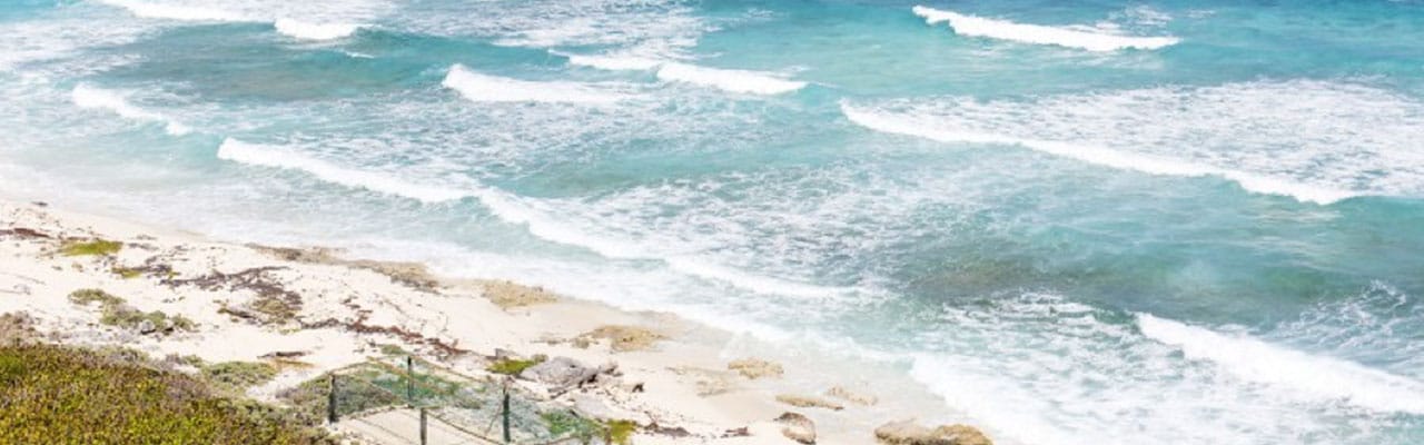 Waves crashing onto beach in Cozumel