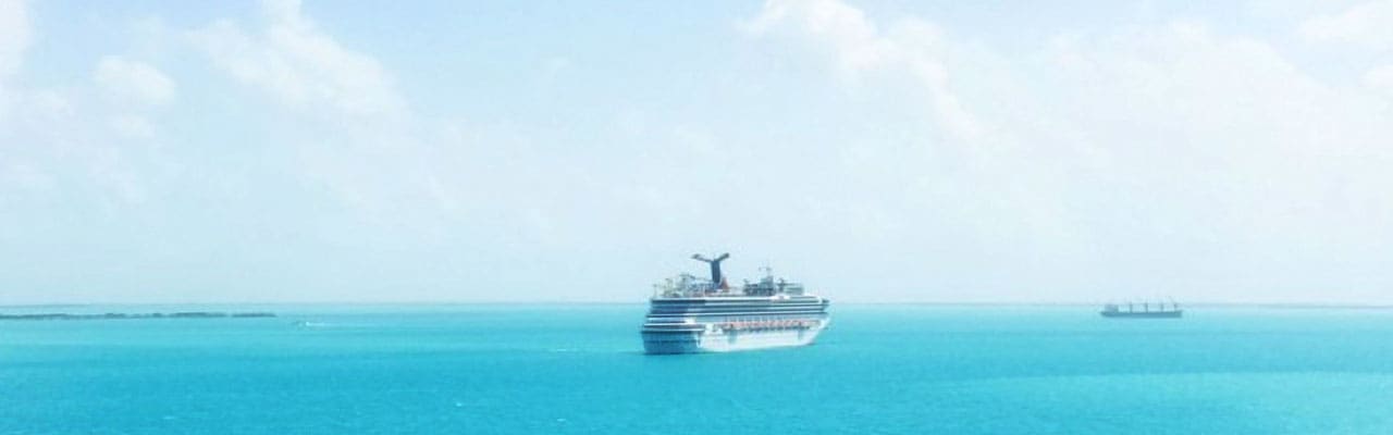 Ship sailing out to ocean over turquoise waters