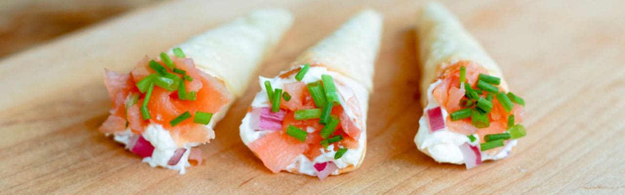 three cones with white cheese, tomato on butcher board