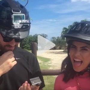 Man and woman with bicycle helmets on smiling, link to Youtube video