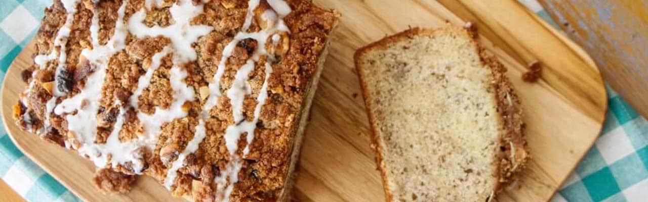 Banner with image of banana rum coffee cake sliced on a wooden cutting board