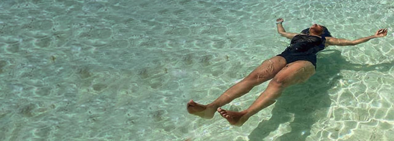 Woman floating on her back in the ocean