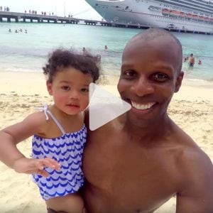 daughter and father pose for a selfie on the beach with Carnival cruise ship in background, link to Youtube video