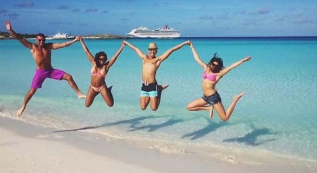 Four friends jumping with joy in Half Moon Cay