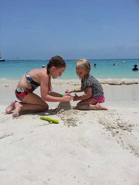 two girls building a sand castle 