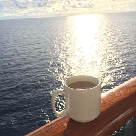 cup of coffee and the view of the sea from a carnival cruise ship