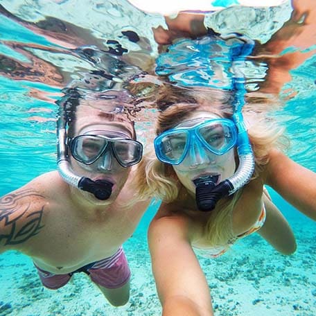 a couple snorkeling and taking a picture together underwater